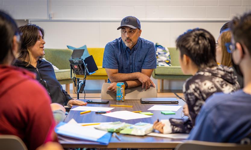 A presenter listens to students pitch ideas